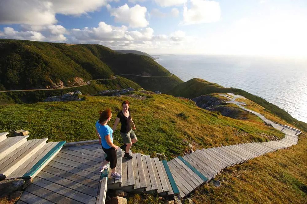 A couple of people standing on top of a wooden ramp in Cape Breton