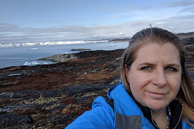 A woman taking a selfie on a rocky beach