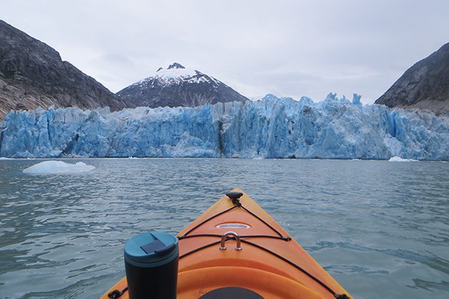 A kayak in the water with a glacier in the background