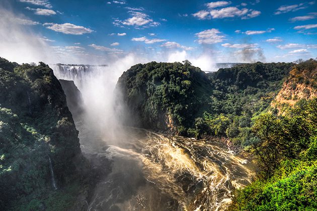 A large waterfall surrounded by lush green trees