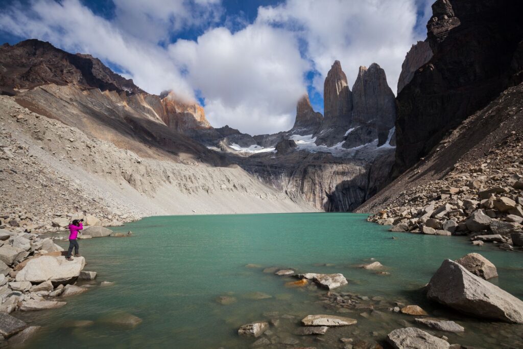a photographer on a rock at the edge of a lake