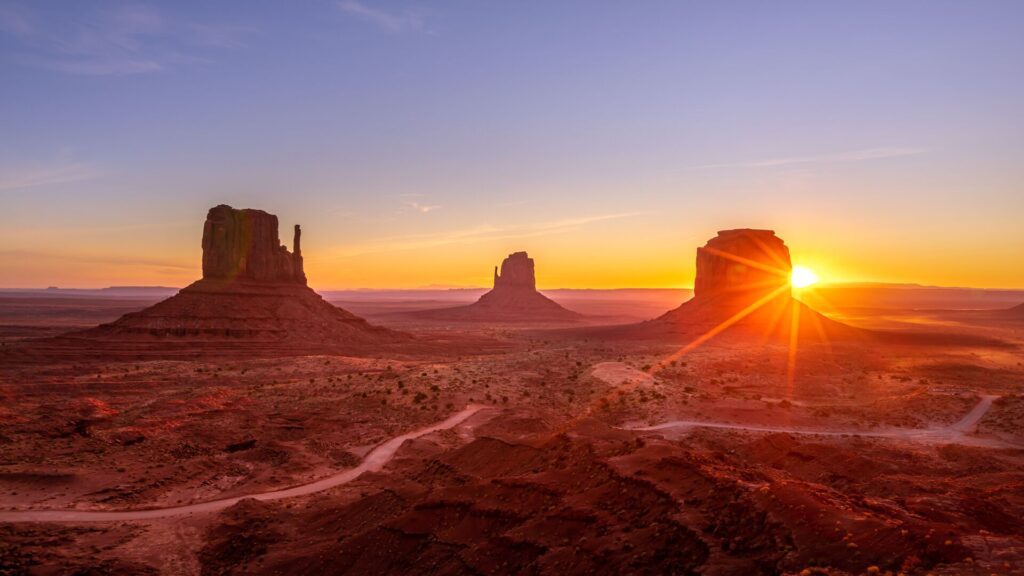 Three stone formations in a desert, Monument Valley.