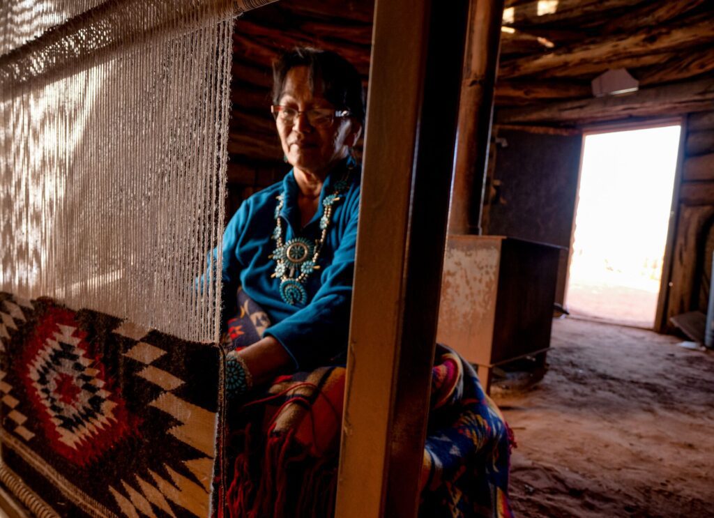 Woman weaving in traditional house