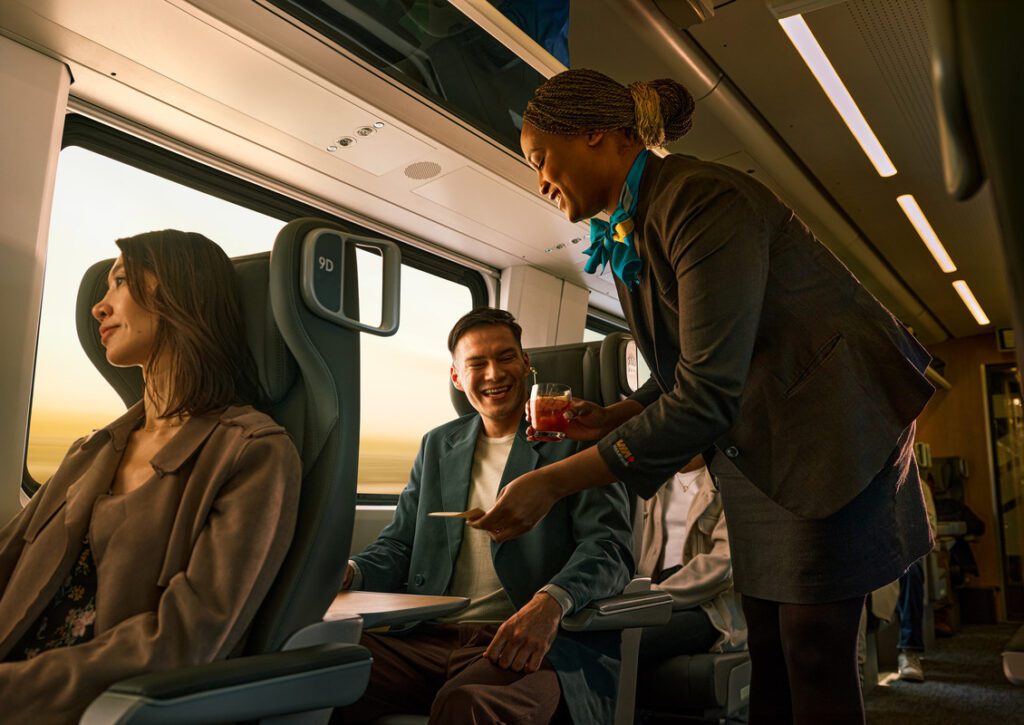person serving someone a drink on a train