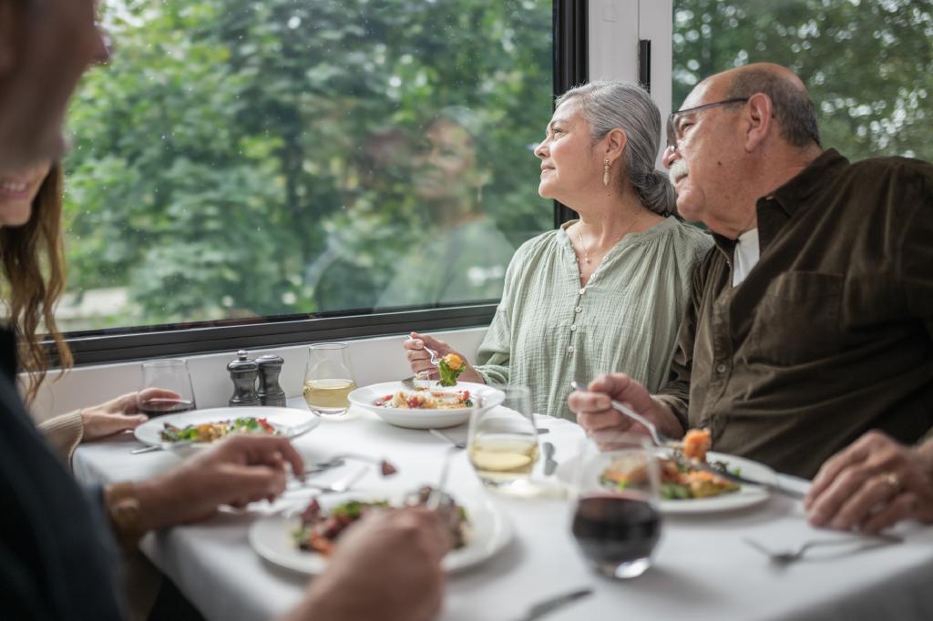 Guests looking at scenery while eating lunch in GoldLeaf dining coach