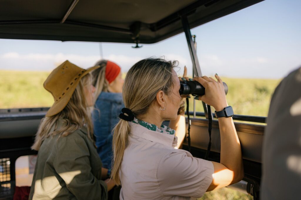 Woman with binoculars in a safari vehicle