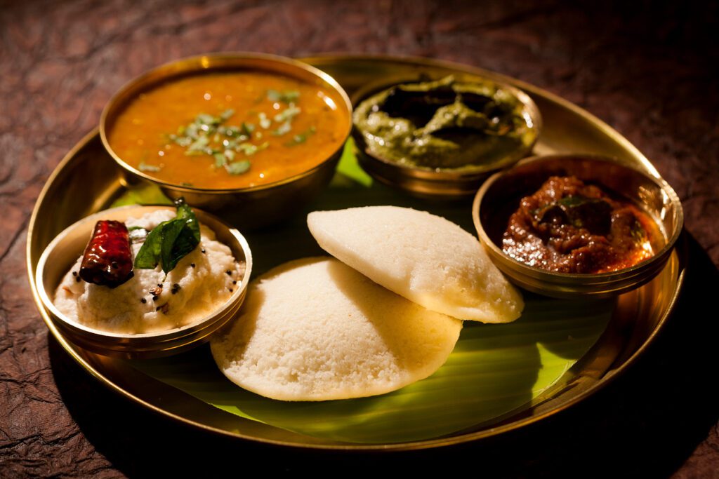 Idli with spread of chutneys and curry