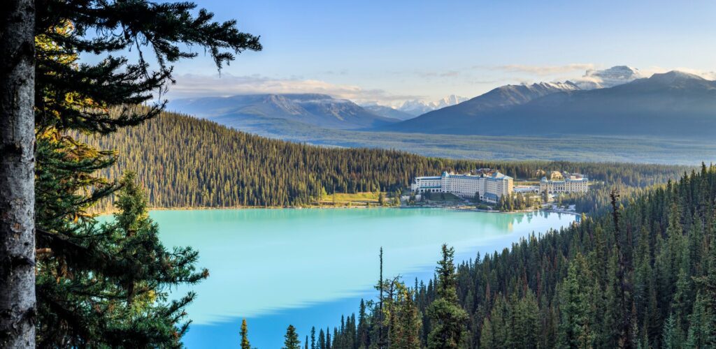Fairmont Chateau Lake Louise castle like accommodation in a forest at the bottom of a lake