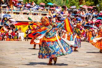 Festival dancer dancing in a colour costume and mask
