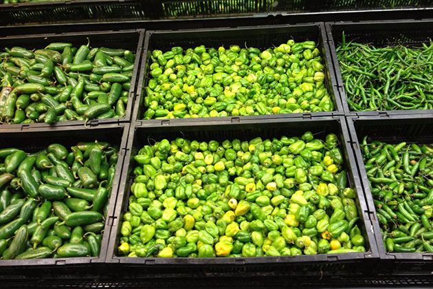 A display of green peppers and other vegetables