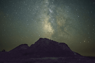 A mountain under a night sky filled with stars