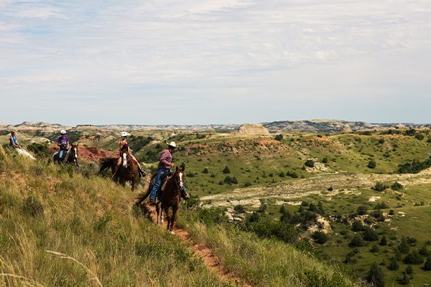 A group of people riding on the backs of horses