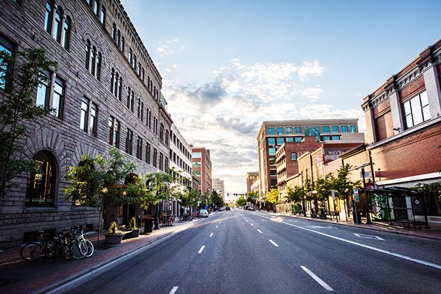 A city street lined with tall brick buildings