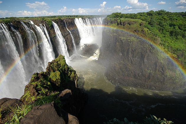 A large waterfall with a rainbow in the sky