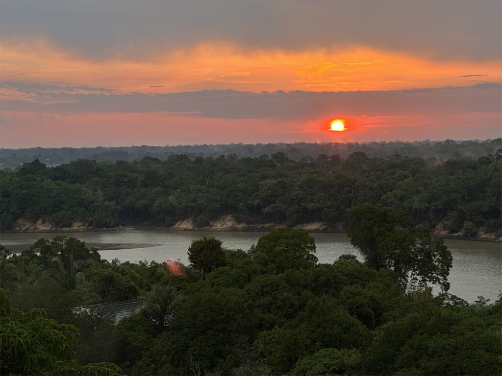 sunset over a forest and river