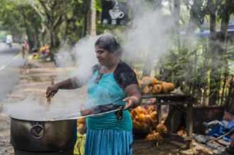 Woman cooking corn, outdoors