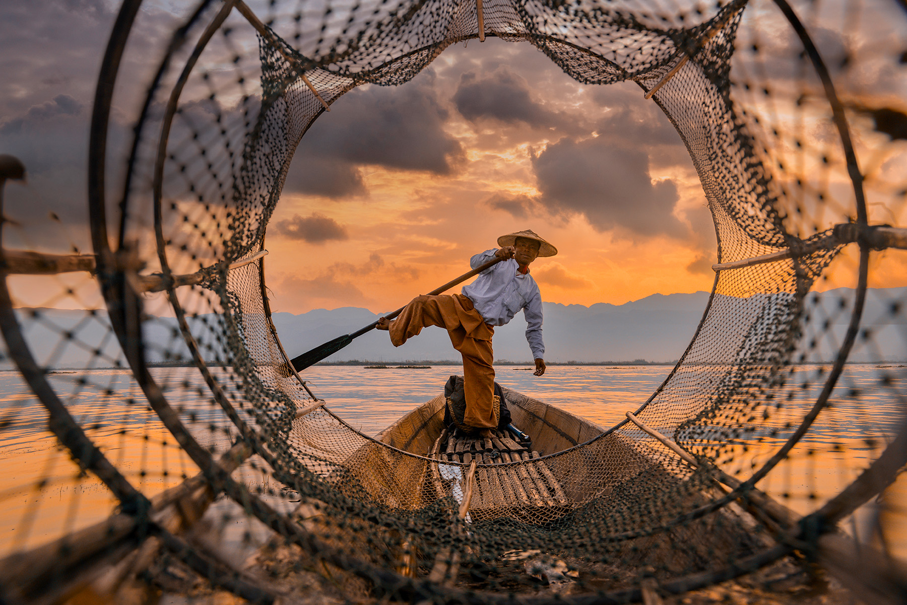 Man Using A Net To Fish On The Mekong River