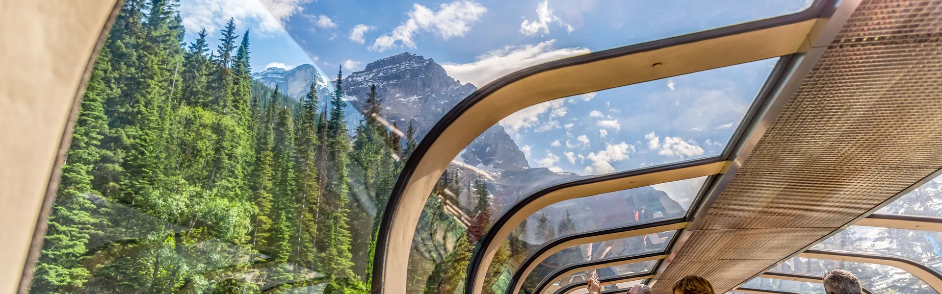 Rocky Mountaineer train traveling through the Rocky Mountains with luxury dining on board 