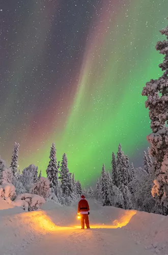 Person Dressed As Santa Looking At The Northern Lights