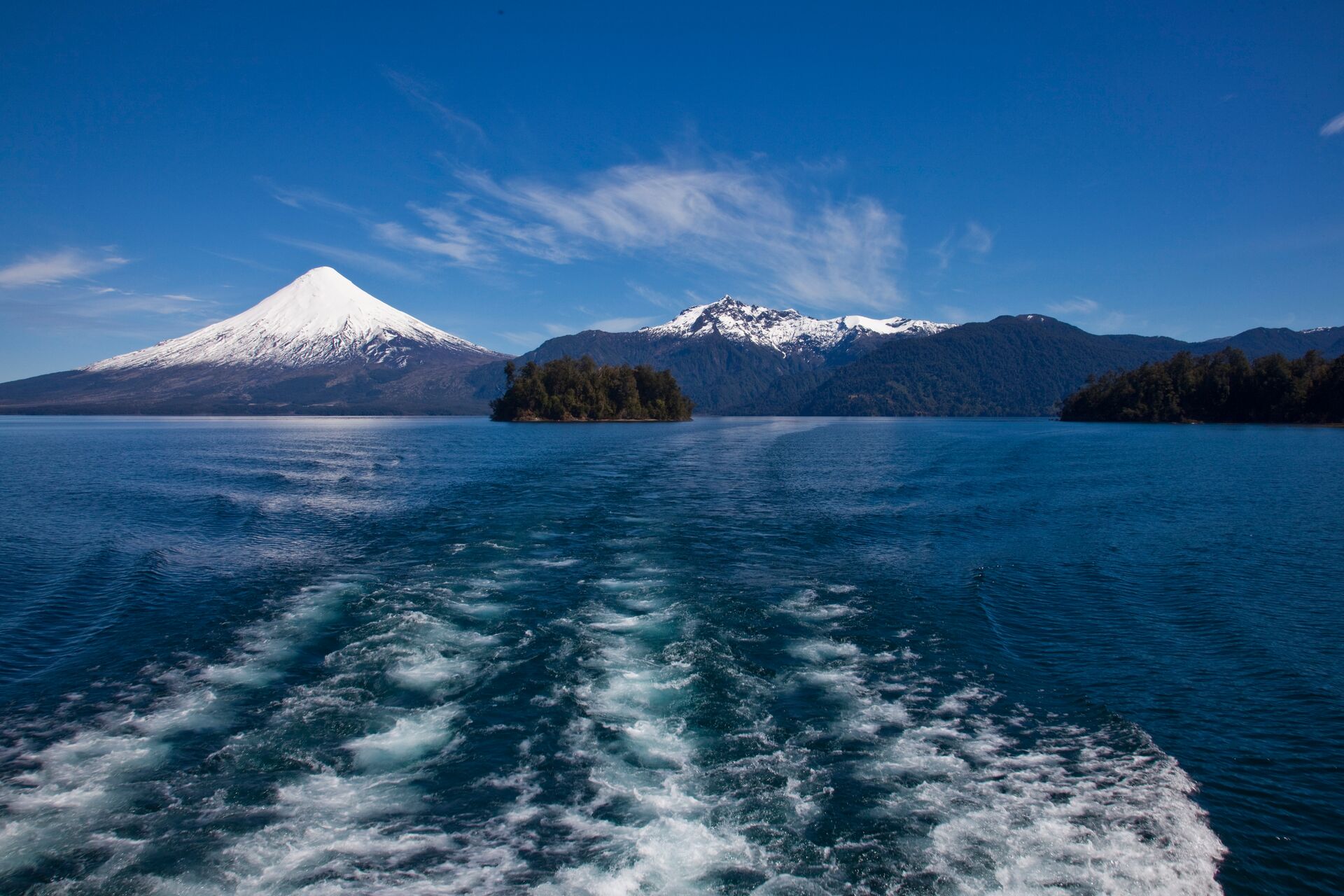 Looking out the back of a boat crossing a lake