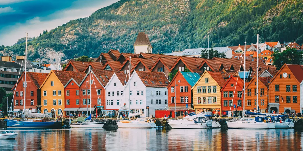 A group of boats floating on the water against a background of buildings