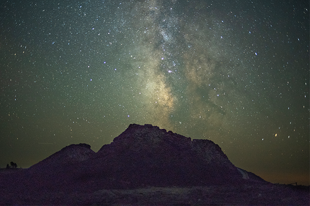 A mountain under a night sky filled with stars