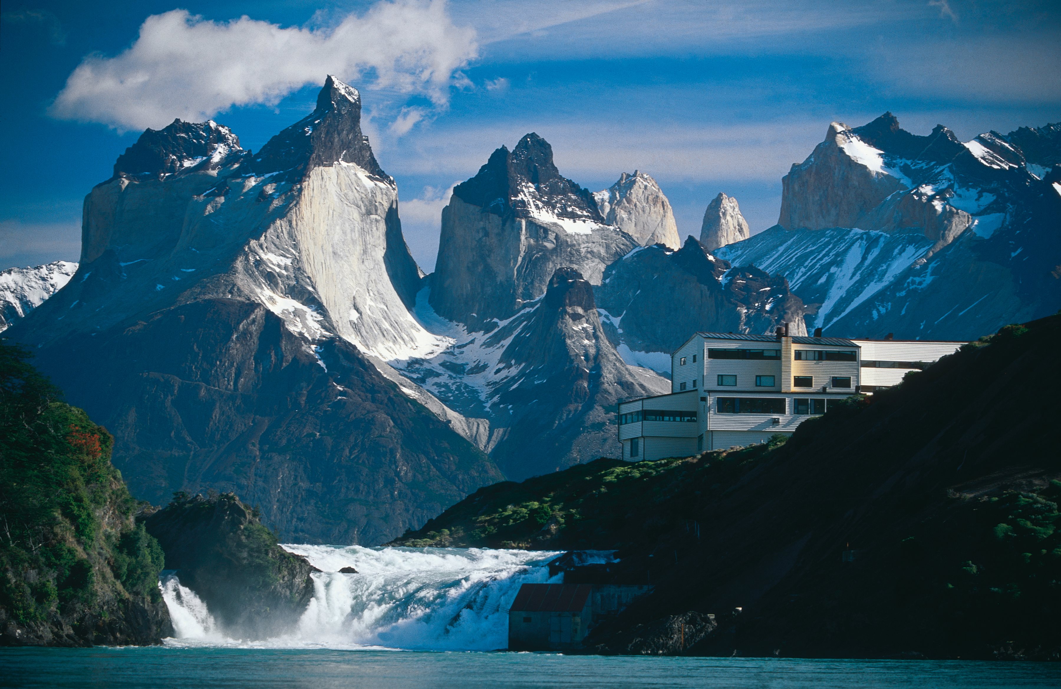 A mountain range with a house in the foreground