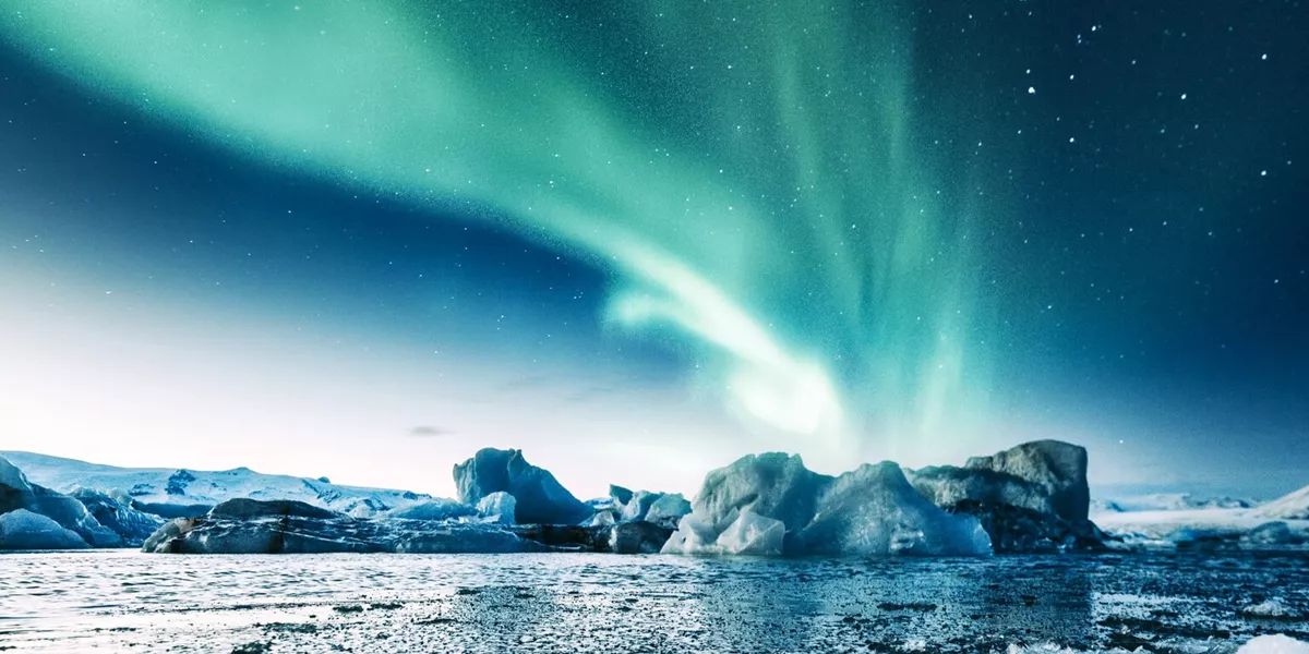 Aurora Borealis over ice formations in the water