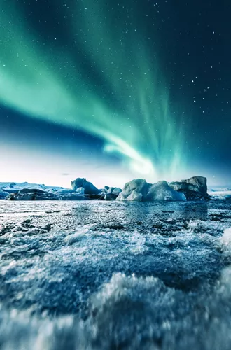 Aurora Borealis over ice formations in the water