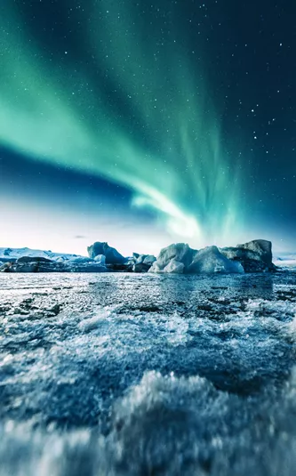 Aurora Borealis over ice formations in the water