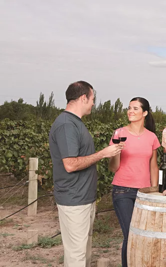 A group of people standing around a barrel of wine
