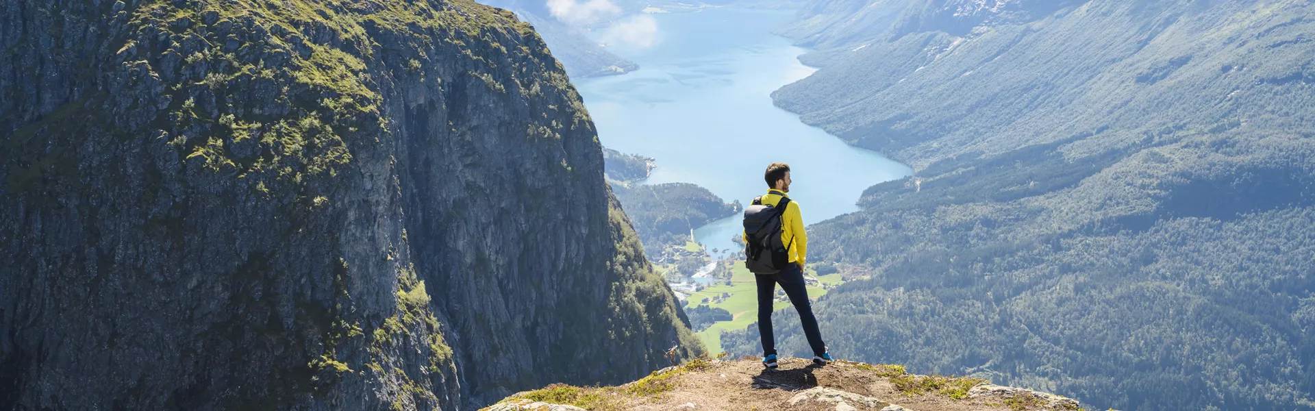 Tourist admiring the view from the top of a mountain in Loen, Norway