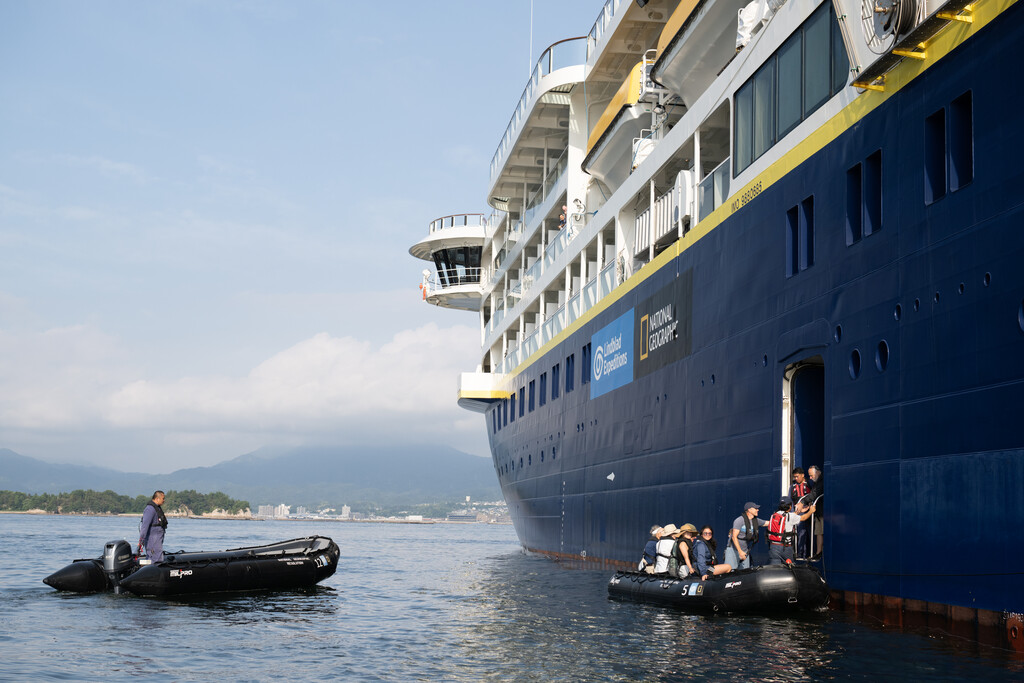 people boarding a zodiac
