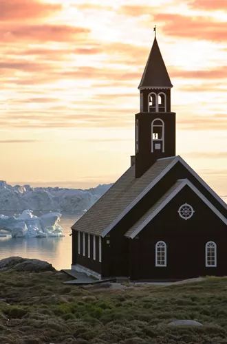 Church on the coast overlooking icebergs floating past