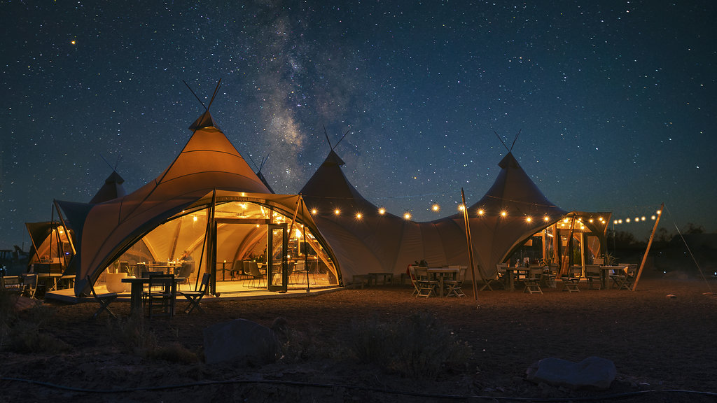 A group of tents sitting under a night sky filled with stars