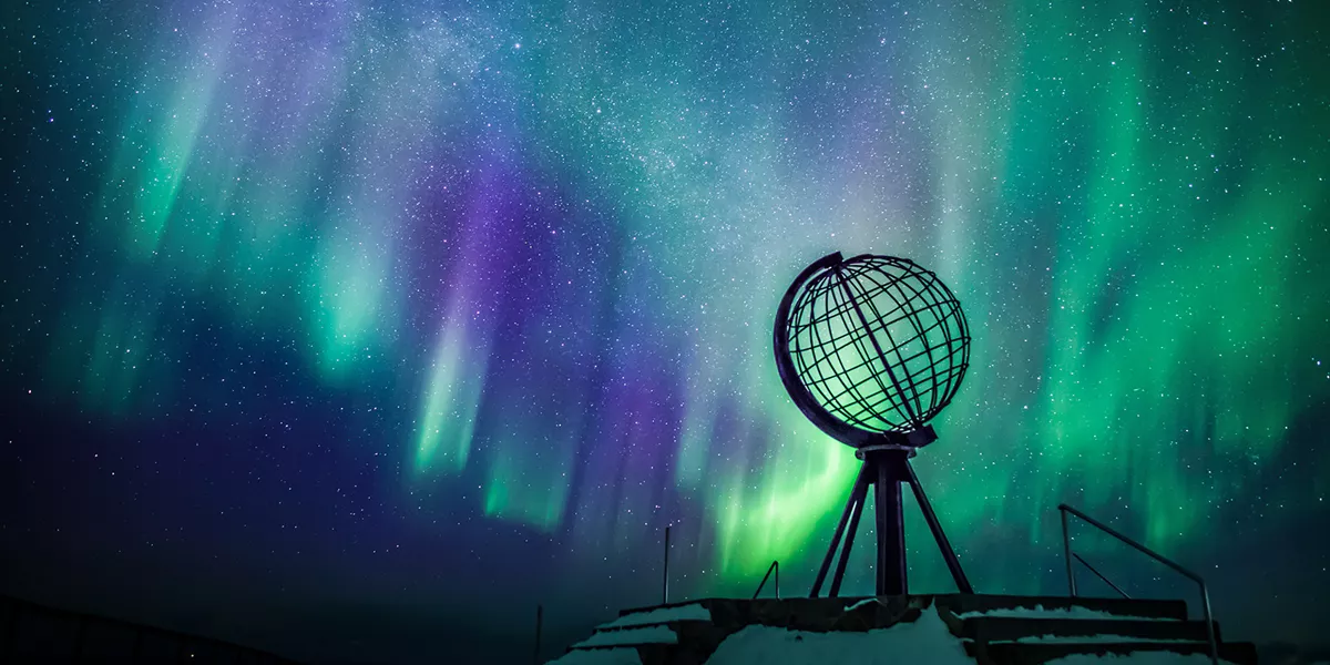 Northern Lights behind globe statue
