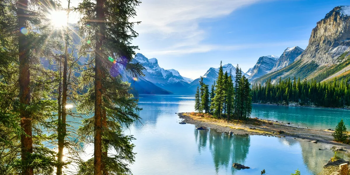 island in the middle of a lake with mountains surrounding