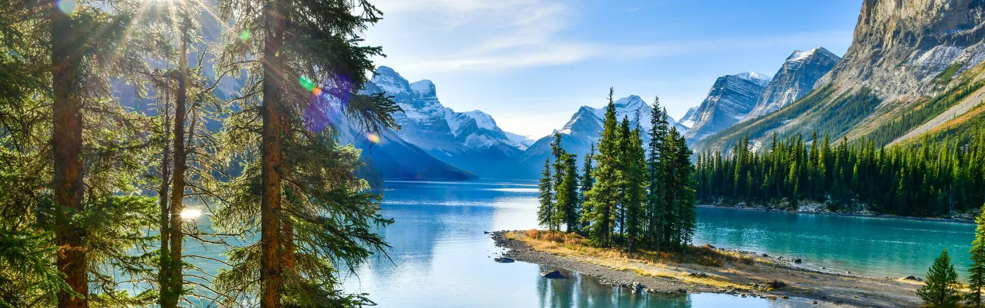 island in the middle of a lake with mountains surrounding