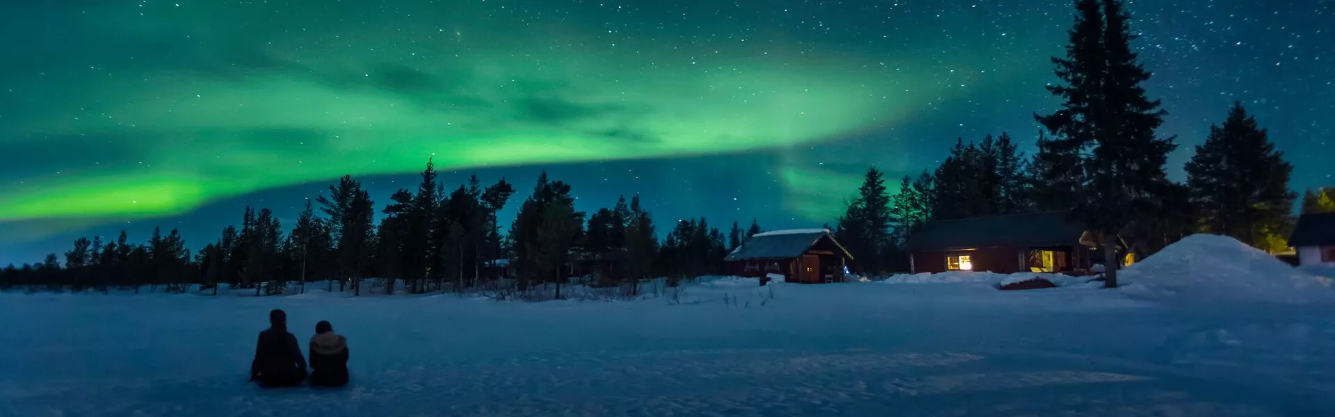 Two People Sitting And Watching the northern lights