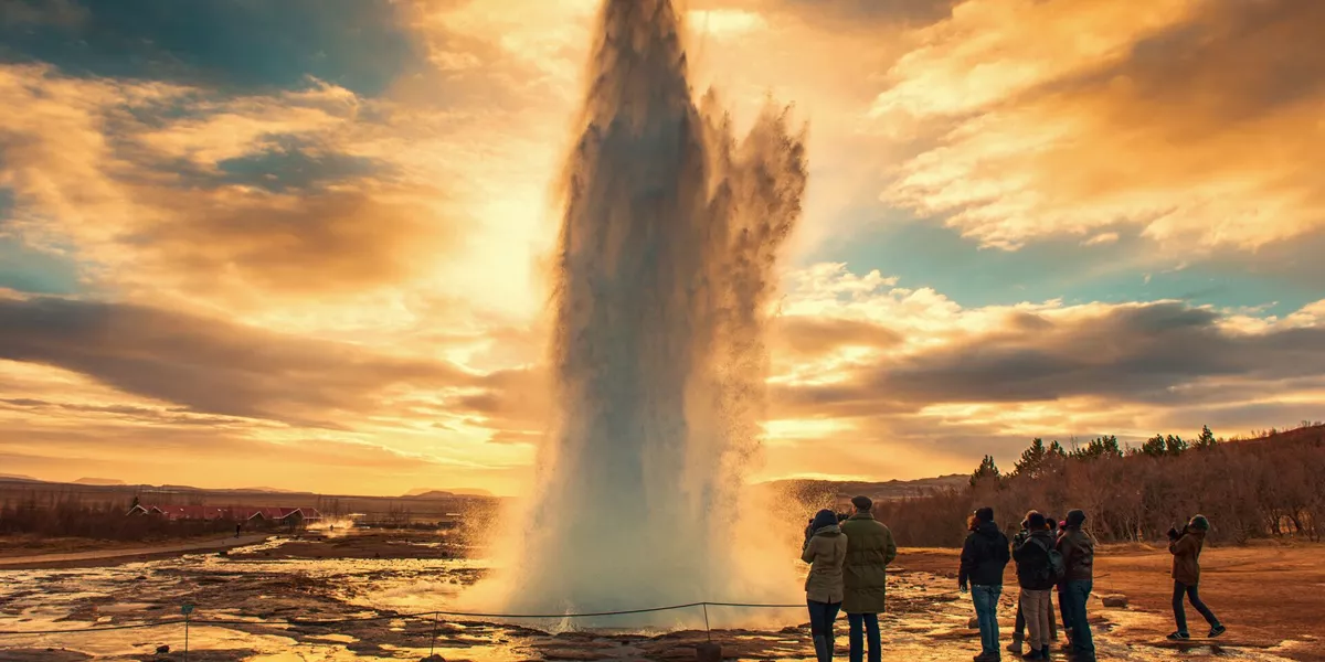 people surrounding and looking at a natural geyser