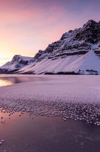 A snow covered mountain by Bow Lake in Canada