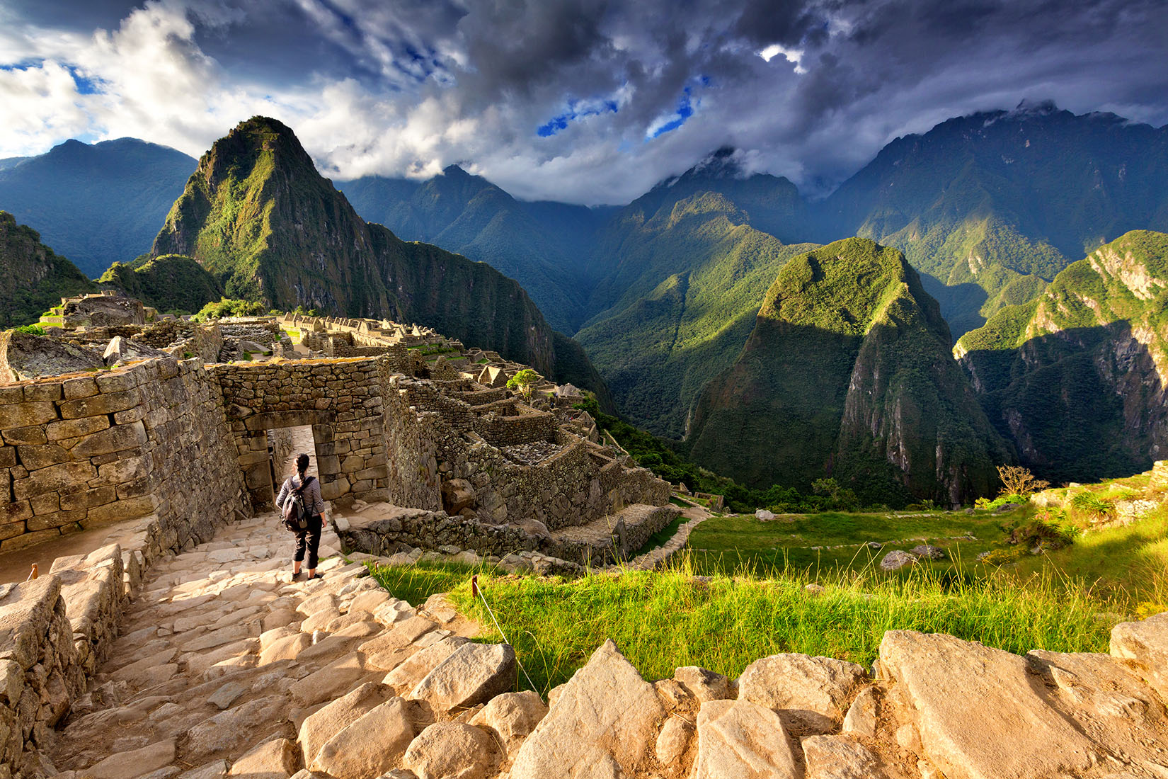 Back View Of Female Tourist Descending Stairs Overlooking Machu Picchu 
