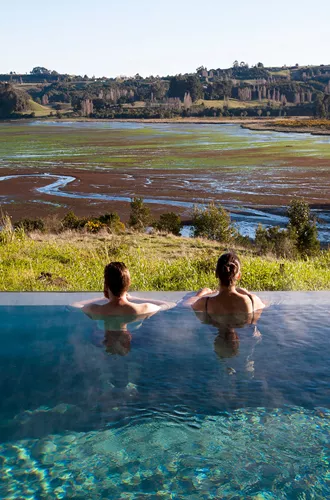 People in a pool overlooking a wild landscape